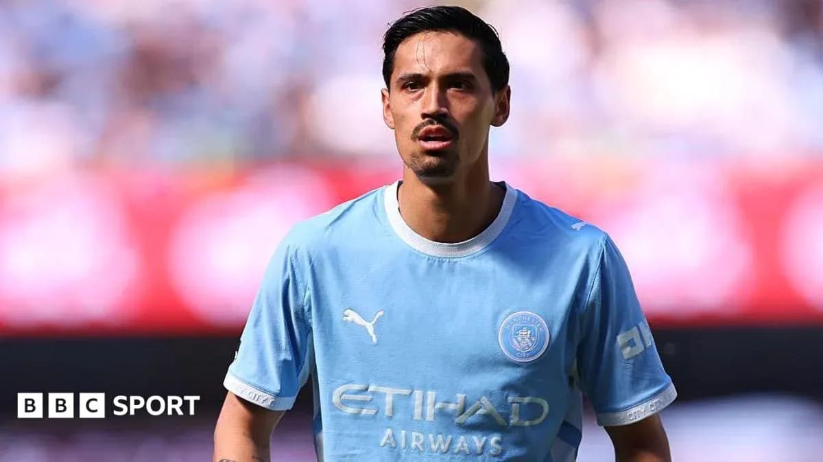 Player wearing light blue Manchester City jersey on field Player wearing light blue Manchester City jersey on field