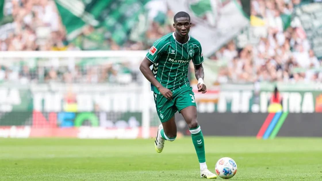 Player in green kit running on the pitch Player in green kit running on the pitch