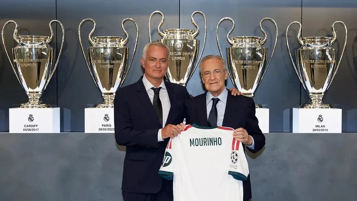 Two men holding a jersey in front of trophies Two men holding a jersey in front of trophies
