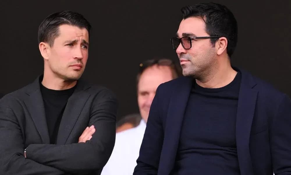 Two men in suits watching an event Two men in suits watching an event