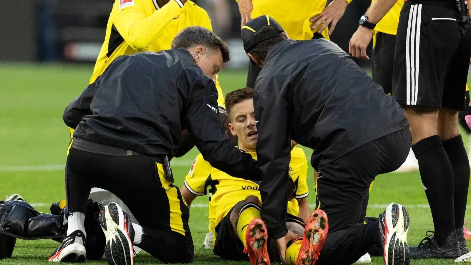 Medical staff attending to injured player on field Medical staff attending to injured player on field