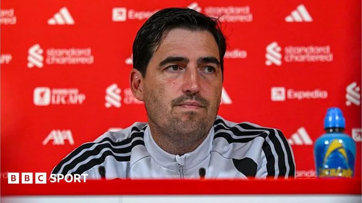 Manager speaking at press conference with red backdrop Manager speaking at press conference with red backdrop