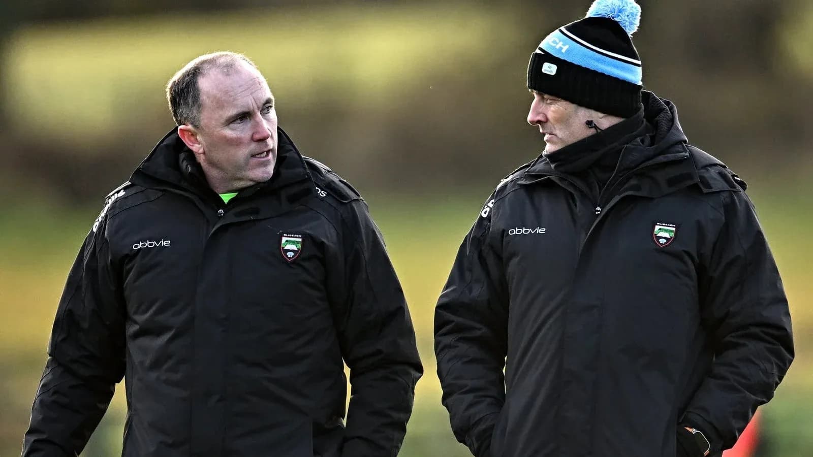 Two coaches discussing strategies on training field Two coaches discussing strategies on training field