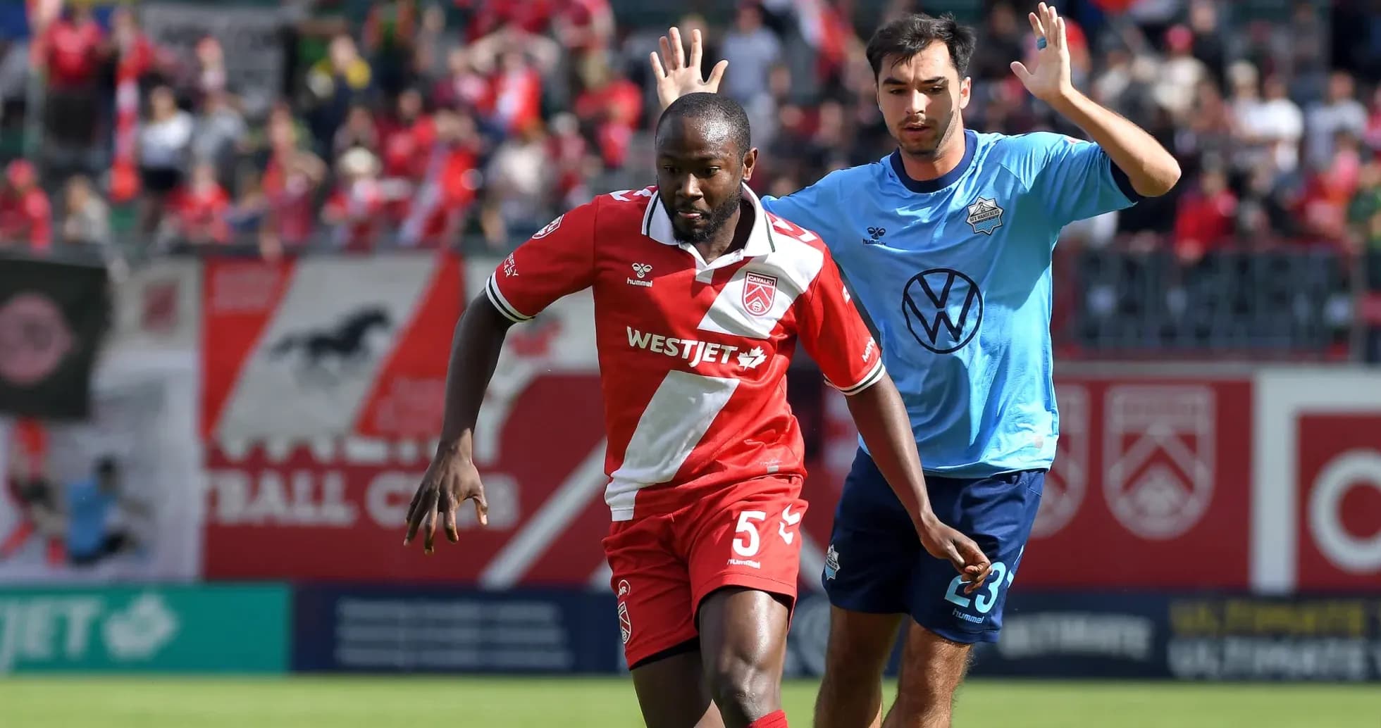 Cavalry FC player dribbling past HFX Wanderers FC opponent Cavalry FC player dribbling past HFX Wanderers FC opponent