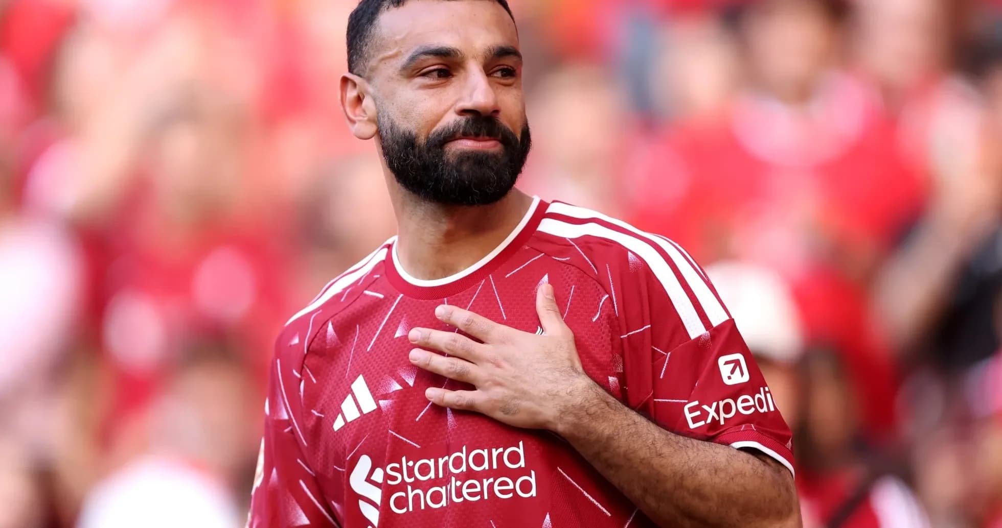 Player in red jersey with hand on chest Player in red jersey with hand on chest