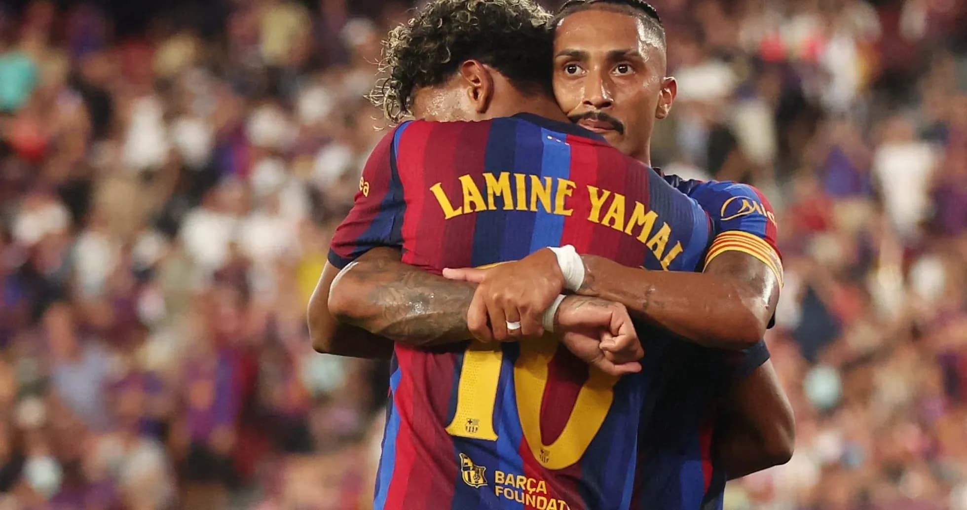 Two FC Barcelona players embracing on the field Two FC Barcelona players embracing on the field