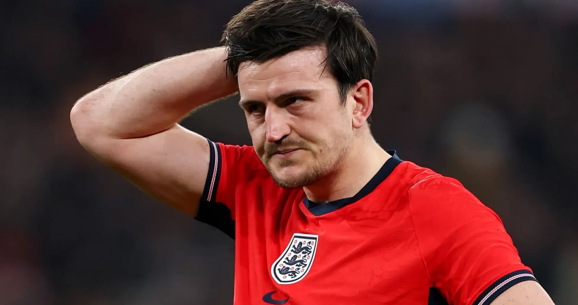 Player in red jersey looking concerned on field Player in red jersey looking concerned on field