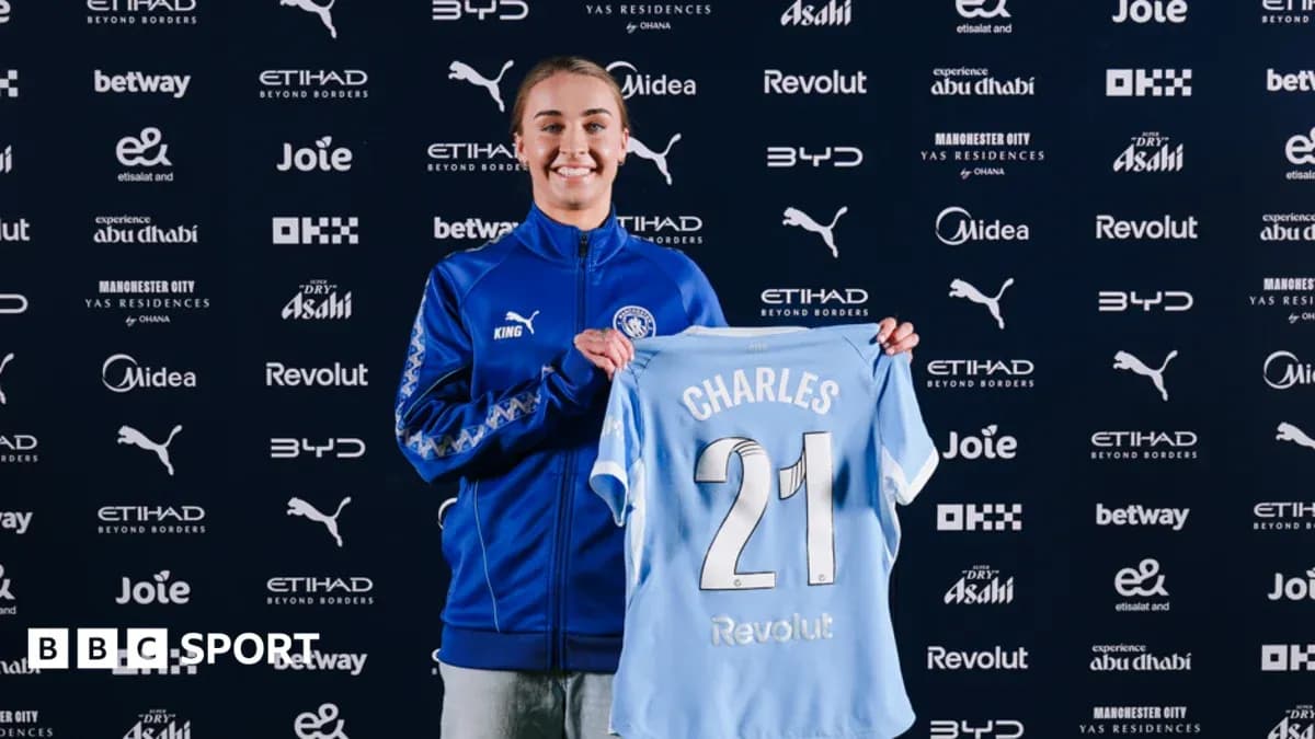 Player holding Manchester City jersey at signing event Player holding Manchester City jersey at signing event