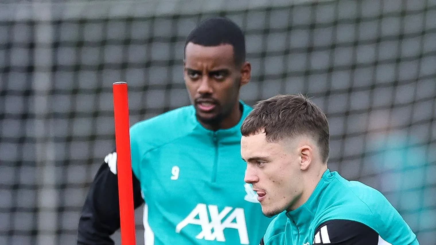 Two players training with a pole on the pitch Two players training with a pole on the pitch