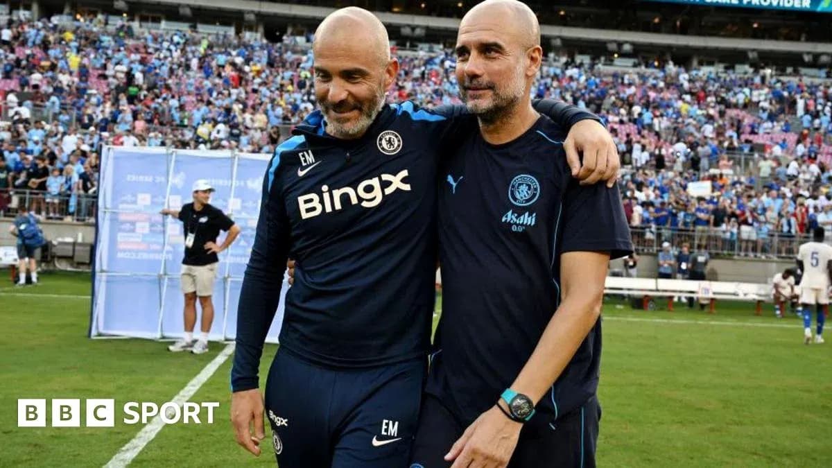 Two coaches walking together on the pitch Two coaches walking together on the pitch