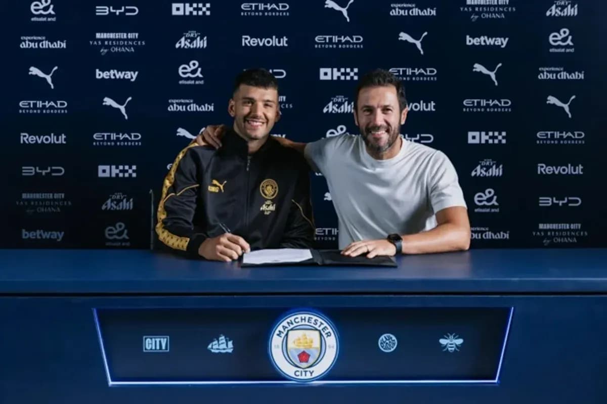 Player signing contract with club representative at table Player signing contract with club representative at table