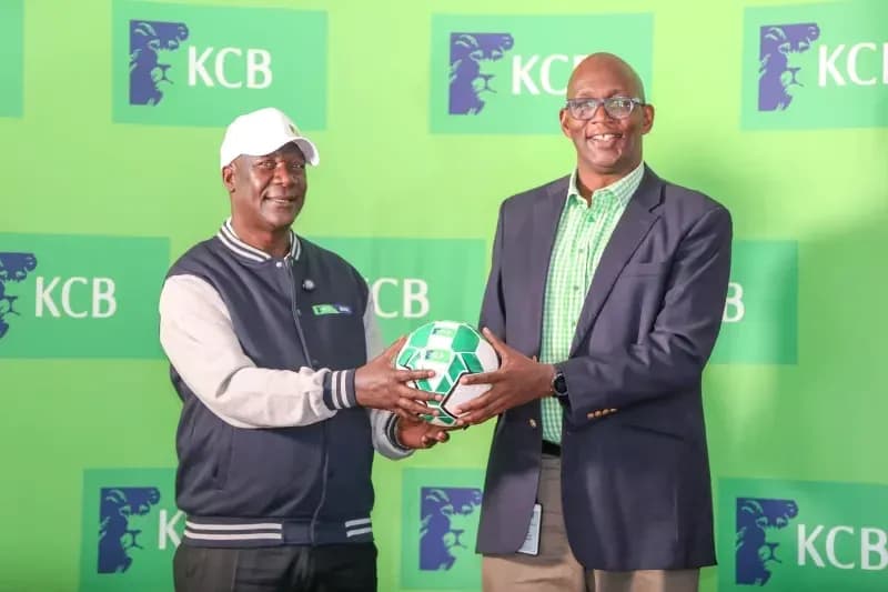 Two men holding a soccer ball at KCB event Two men holding a soccer ball at KCB event