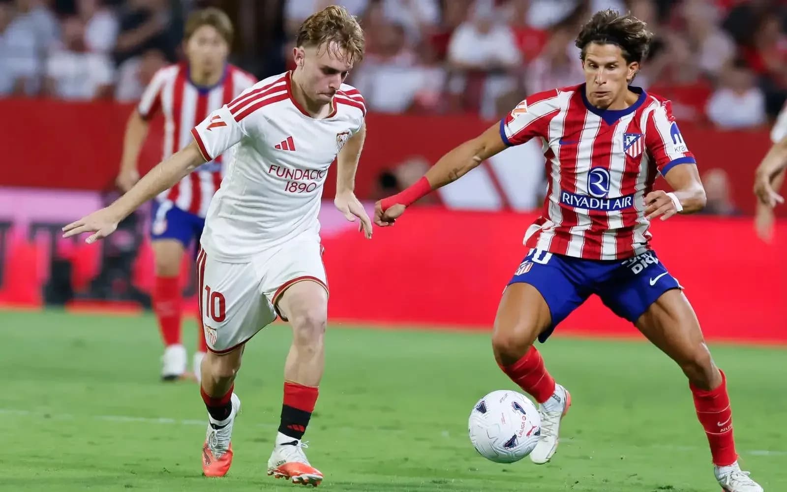 Sevilla player dribbling against Atletico Madrid Sevilla player dribbling against Atletico Madrid