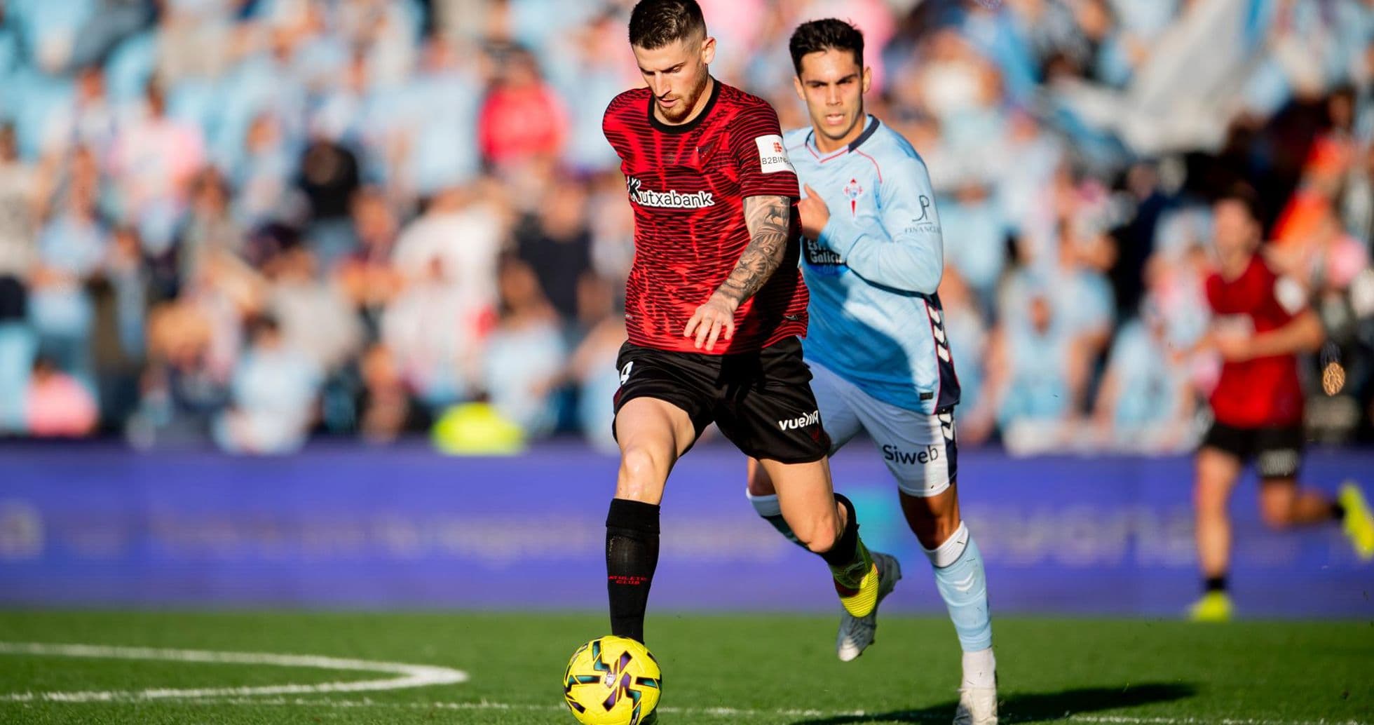 Athletic Club player dribbling past Celta Vigo defender Athletic Club player dribbling past Celta Vigo defender