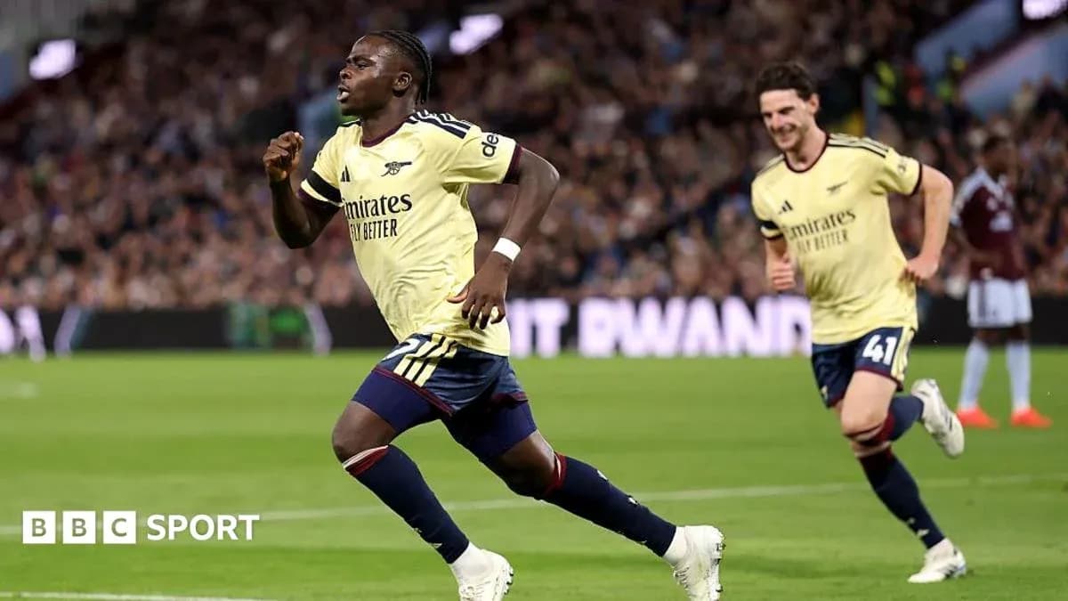 Player celebrating a goal with teammates on pitch Player celebrating a goal with teammates on pitch