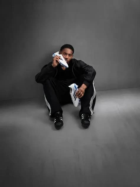 Athlete sitting with soccer shoes in hand Athlete sitting with soccer shoes in hand