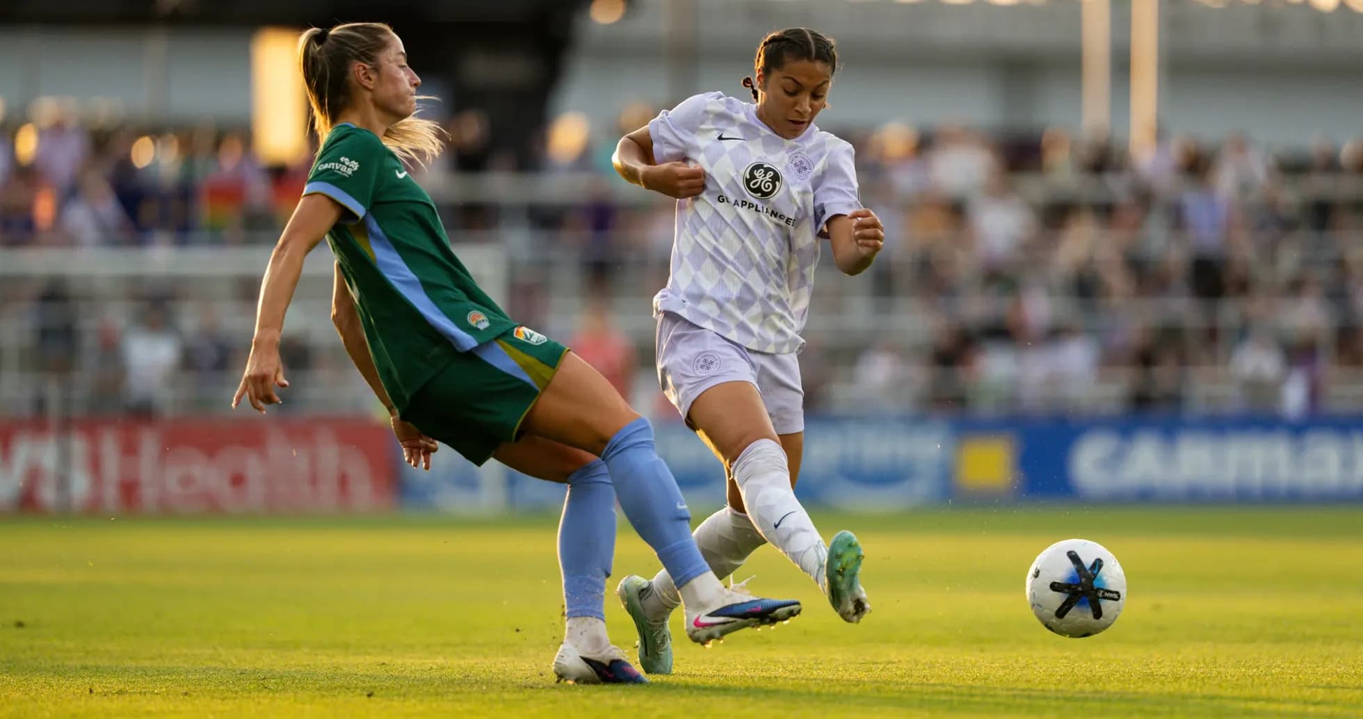 Players competing for the ball during NWSL match Players competing for the ball during NWSL match