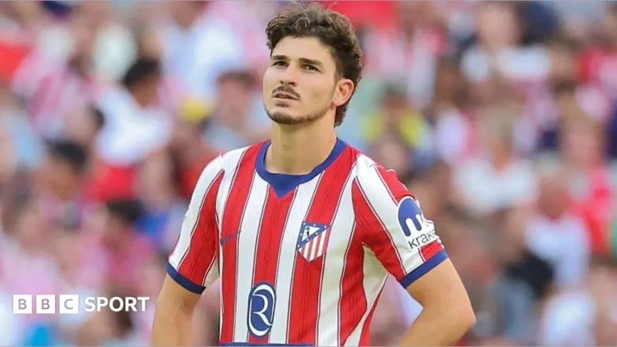 Atletico Madrid player during match with fans in background Atletico Madrid player during match with fans in background
