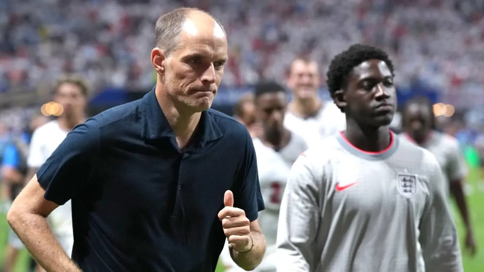 Coach and player walking off the pitch after match Coach and player walking off the pitch after match