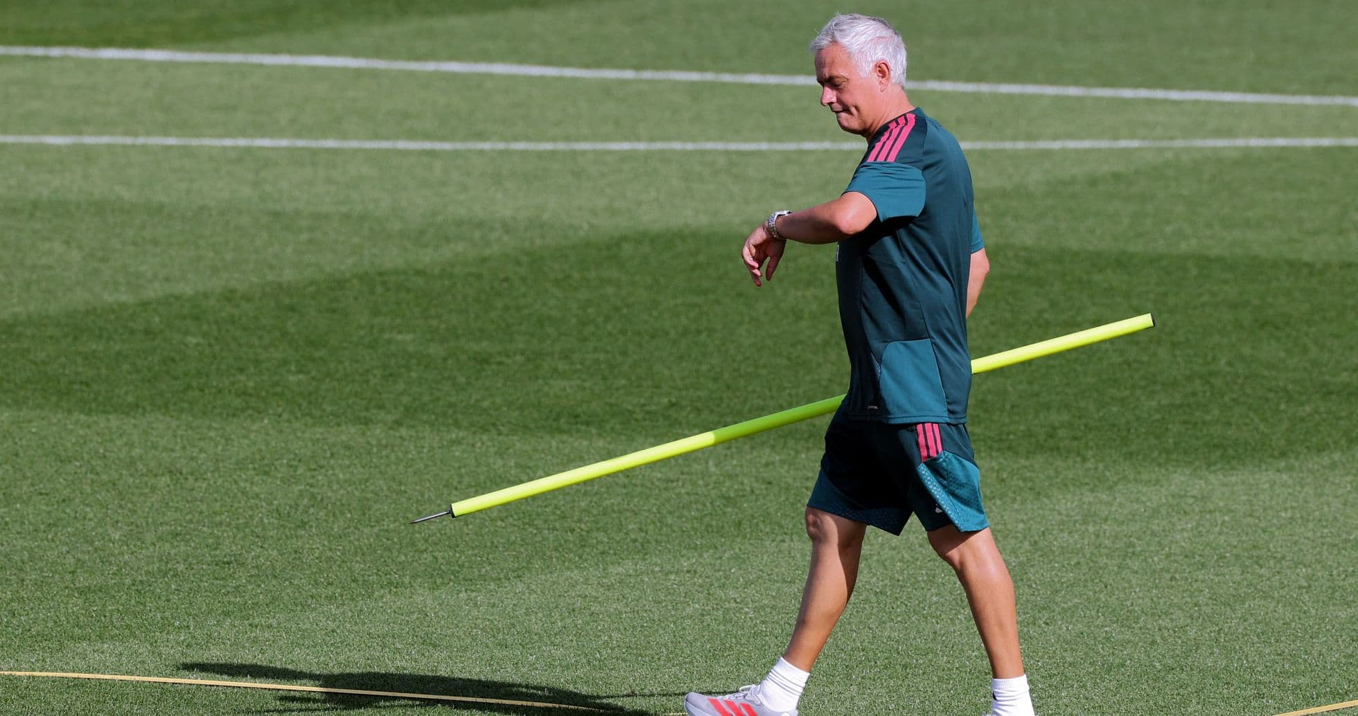 Coach walking with training equipment on the field Coach walking with training equipment on the field