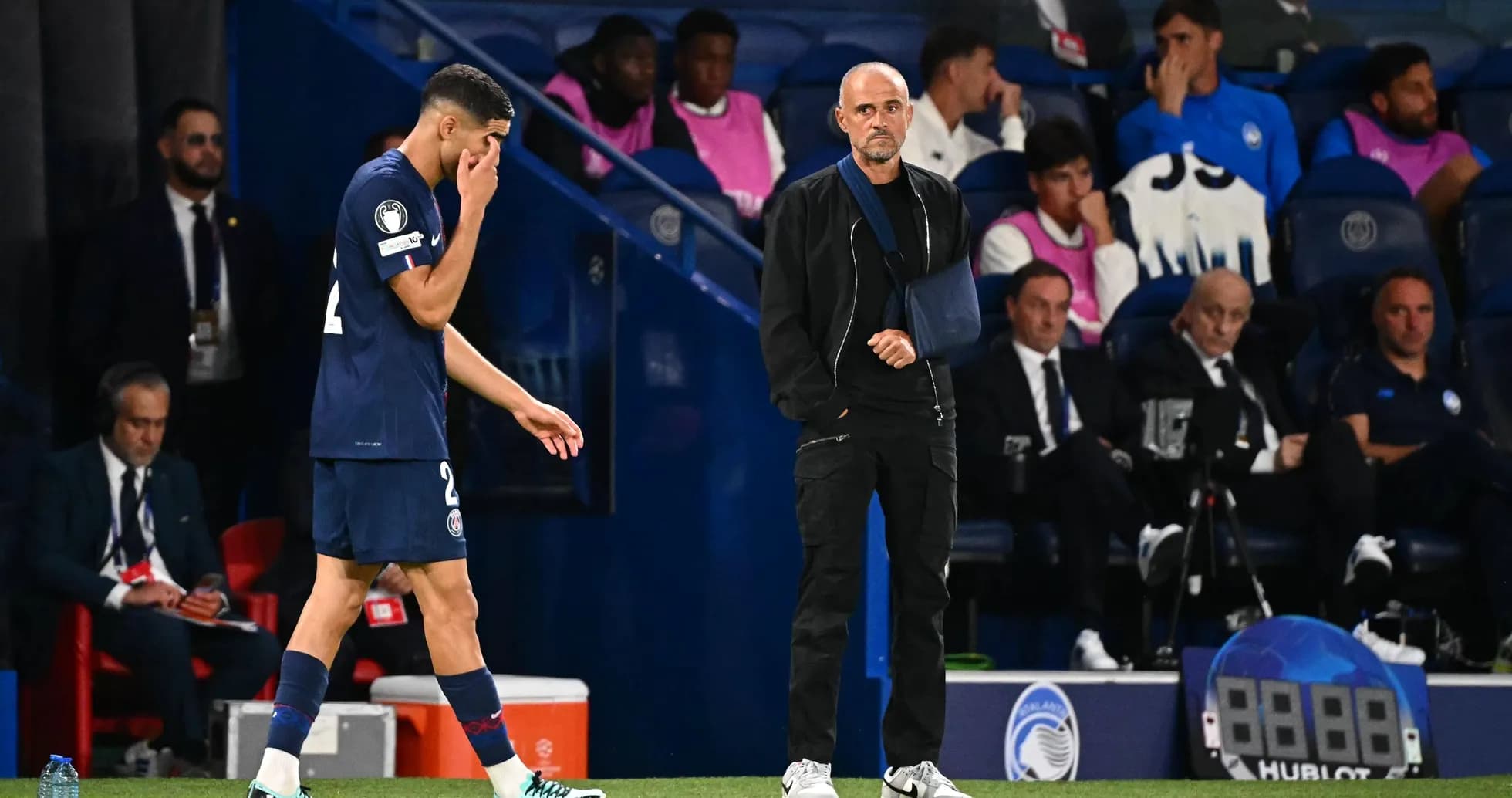 Player leaving field with coach observing during match Player leaving field with coach observing during match