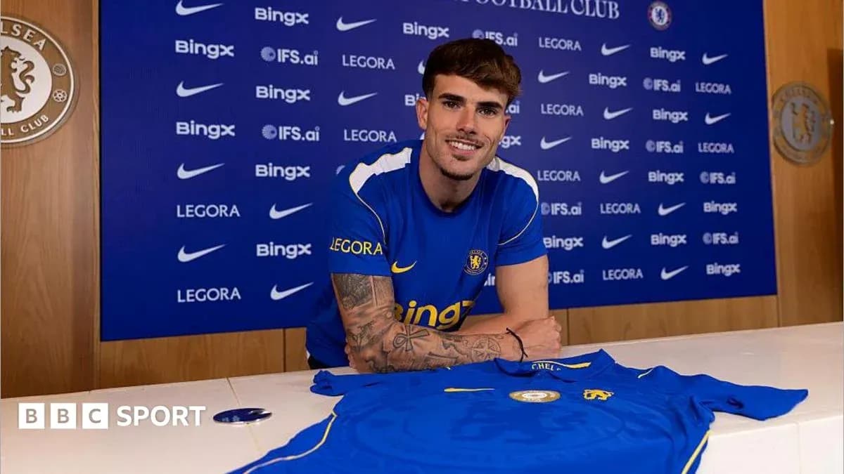 Player posing with Chelsea shirt at press conference Player posing with Chelsea shirt at press conference