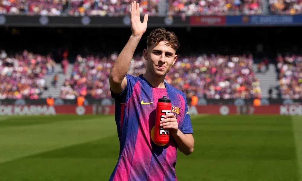Player waving while holding a water bottle on field Player waving while holding a water bottle on field