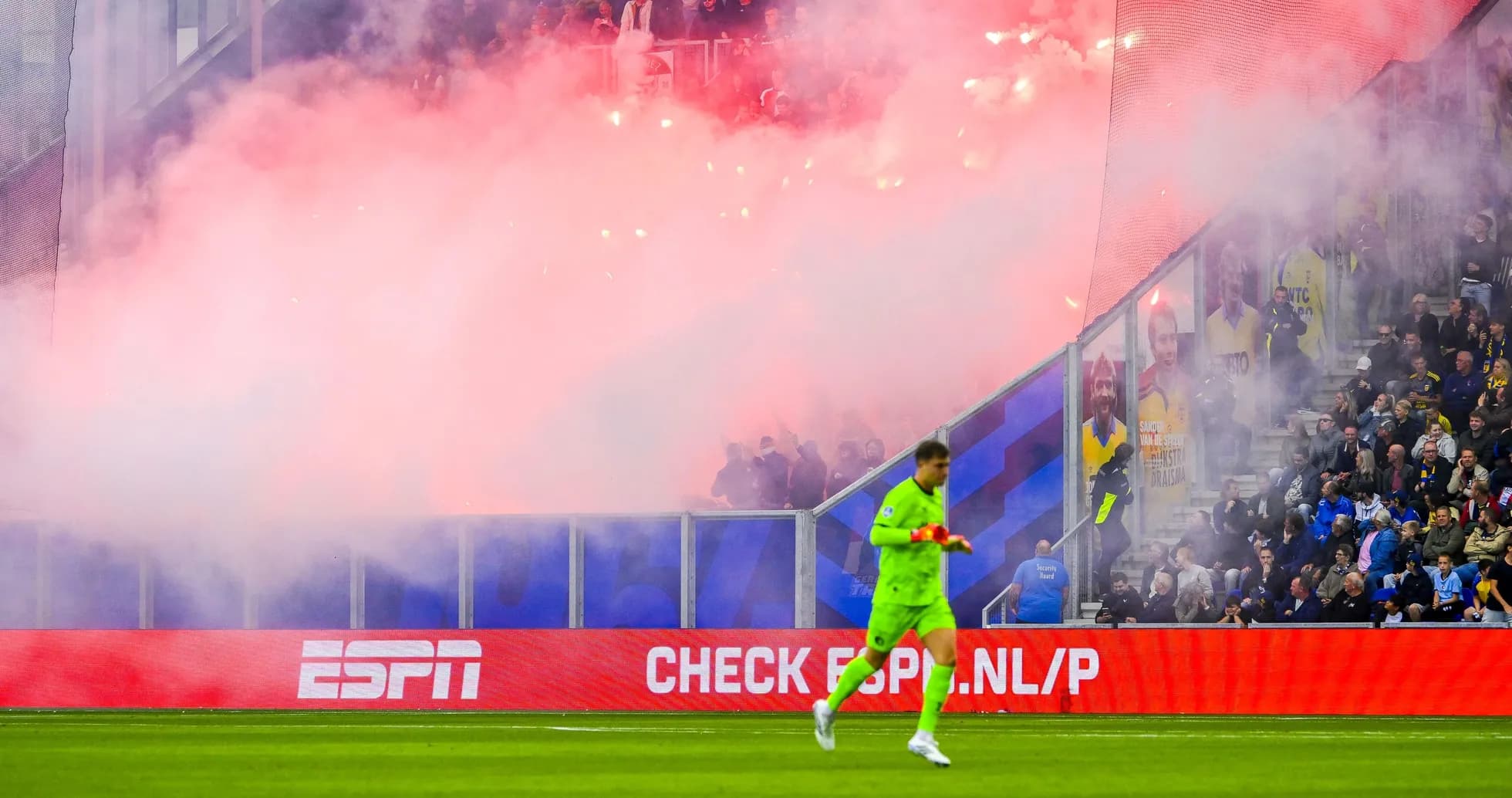 Goalkeeper walking past smoky crowd during match Goalkeeper walking past smoky crowd during match
