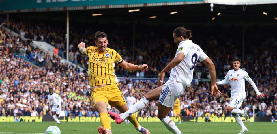 Leeds player tackling Brighton opponent during match Leeds player tackling Brighton opponent during match