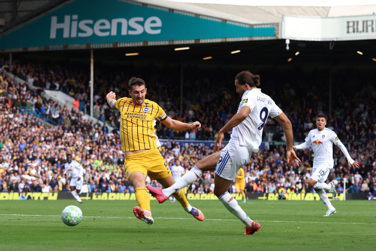Leeds player tackling Brighton opponent during match Leeds player tackling Brighton opponent during match