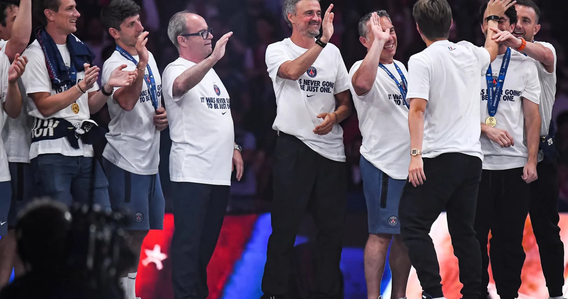 Team celebrating on stage after winning championship Team celebrating on stage after winning championship