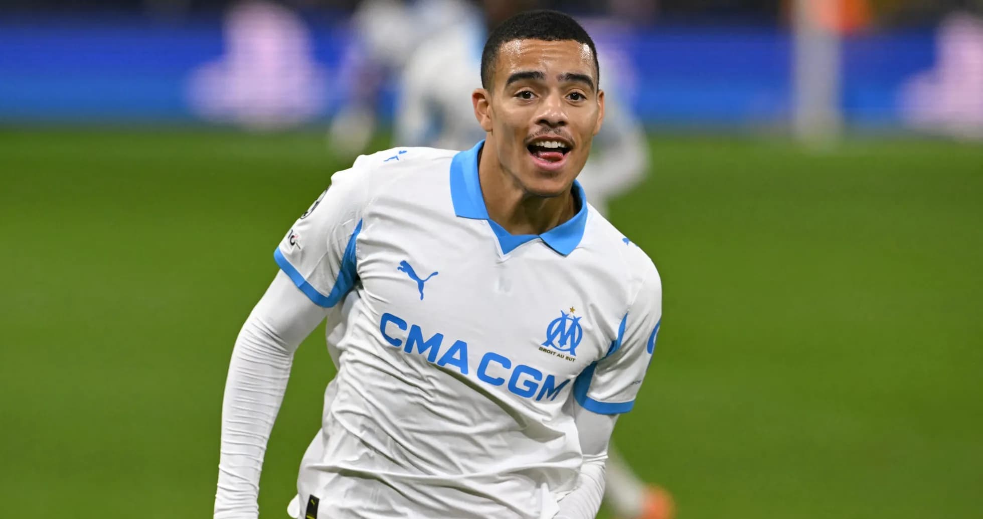 Player celebrating goal in Marseille jersey on pitch Player celebrating goal in Marseille jersey on pitch