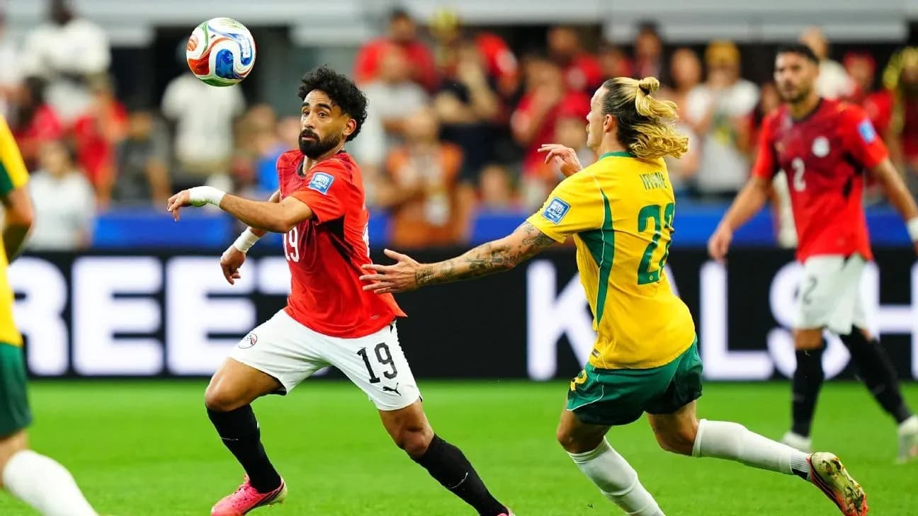 Egyptian player dribbling past Australian opponent during match Egyptian player dribbling past Australian opponent during match