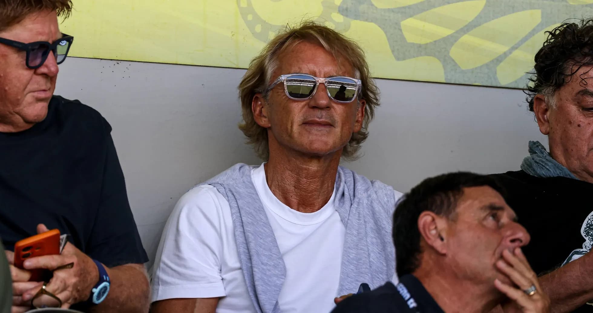 Man wearing sunglasses sitting in the stands Man wearing sunglasses sitting in the stands