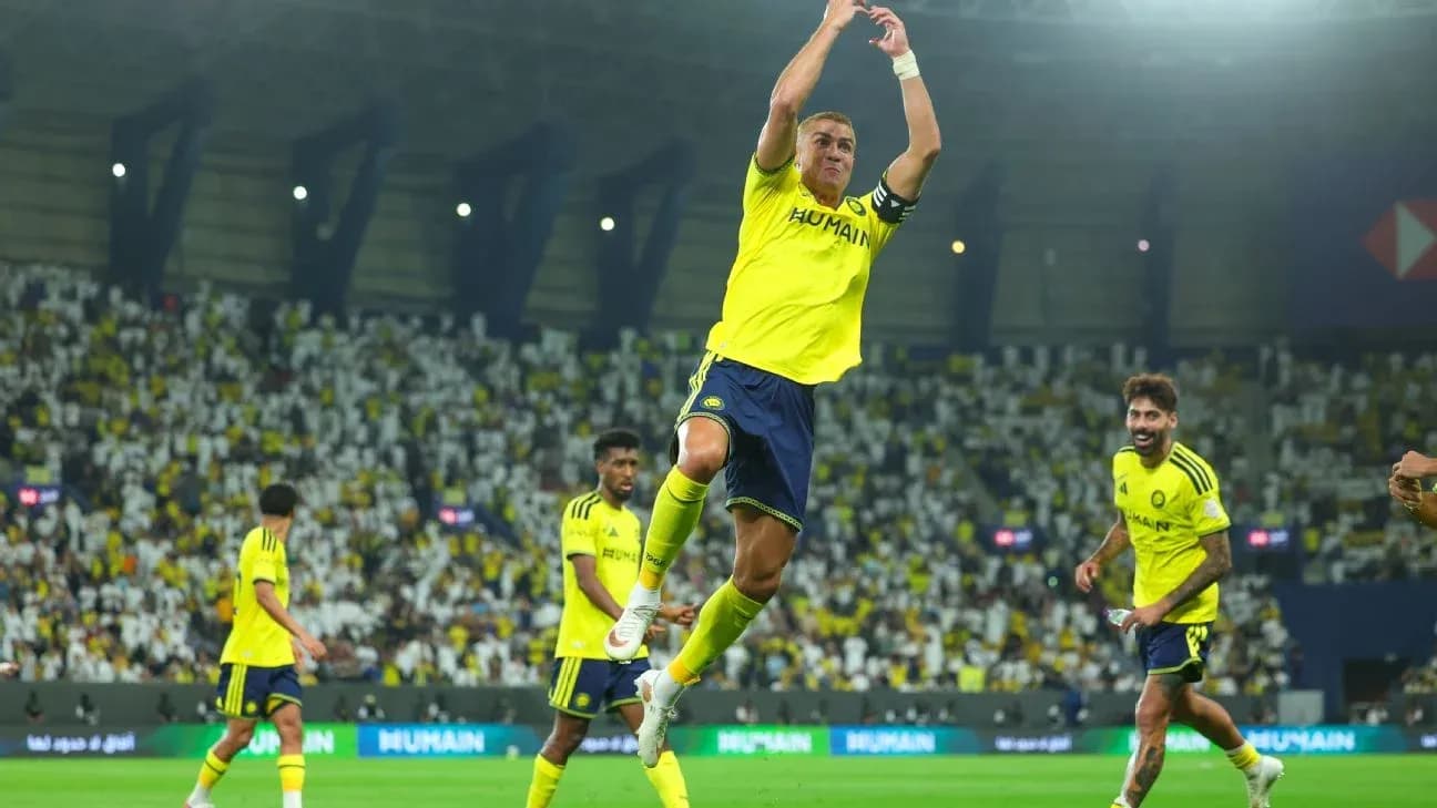 Player celebrating a goal with teammates on pitch Player celebrating a goal with teammates on pitch