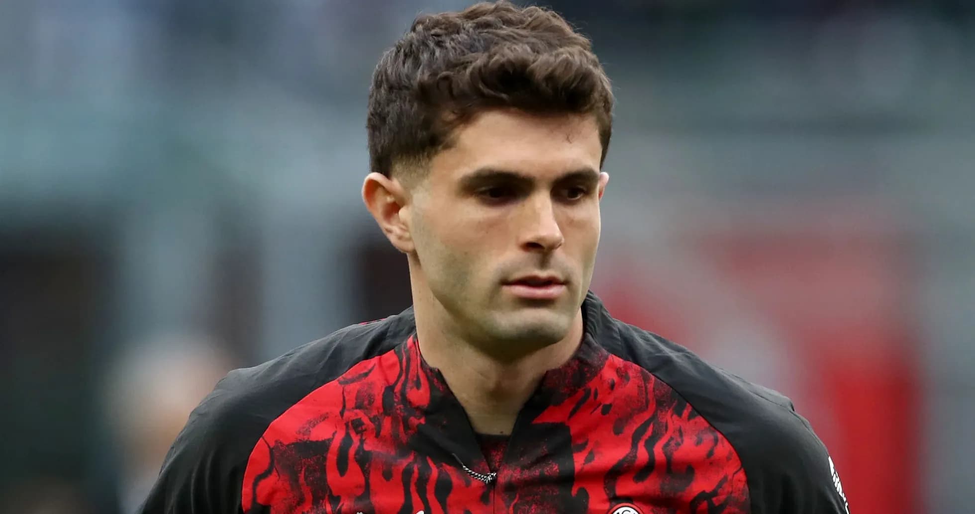 Player in AC Milan jersey walking on pitch Player in AC Milan jersey walking on pitch