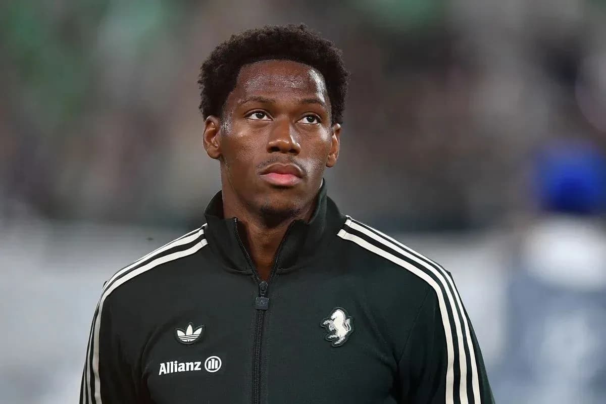 Player in black warm-up jacket looking ahead Player in black warm-up jacket looking ahead
