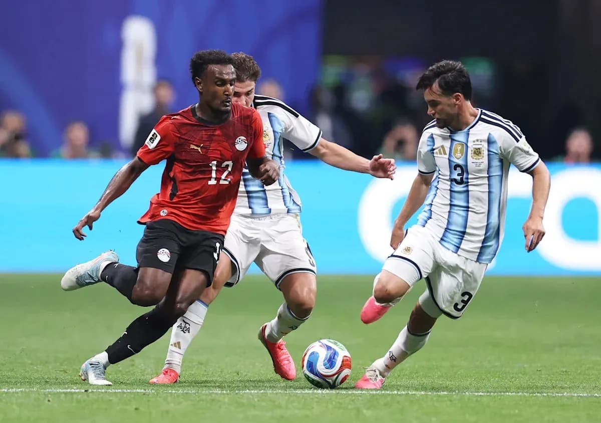 Egyptian player dribbling past Argentine defenders during match Egyptian player dribbling past Argentine defenders during match