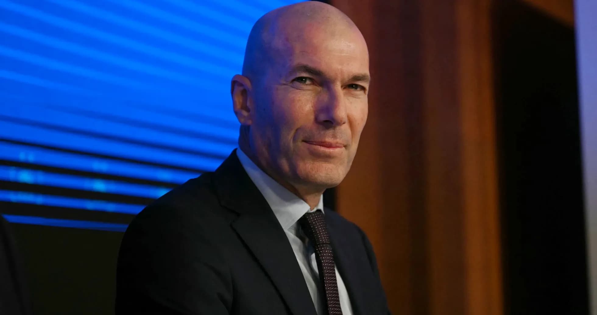 Man in suit sitting at press conference table Man in suit sitting at press conference table