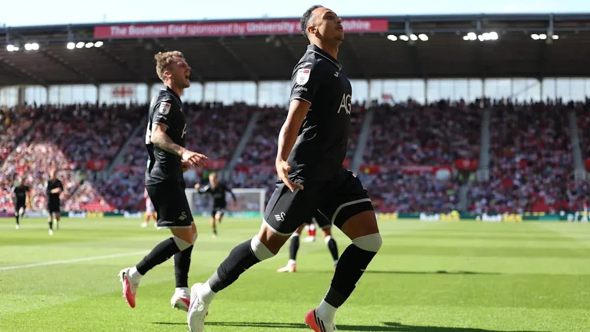 Swansea City player celebrating a goal on pitch Swansea City player celebrating a goal on pitch