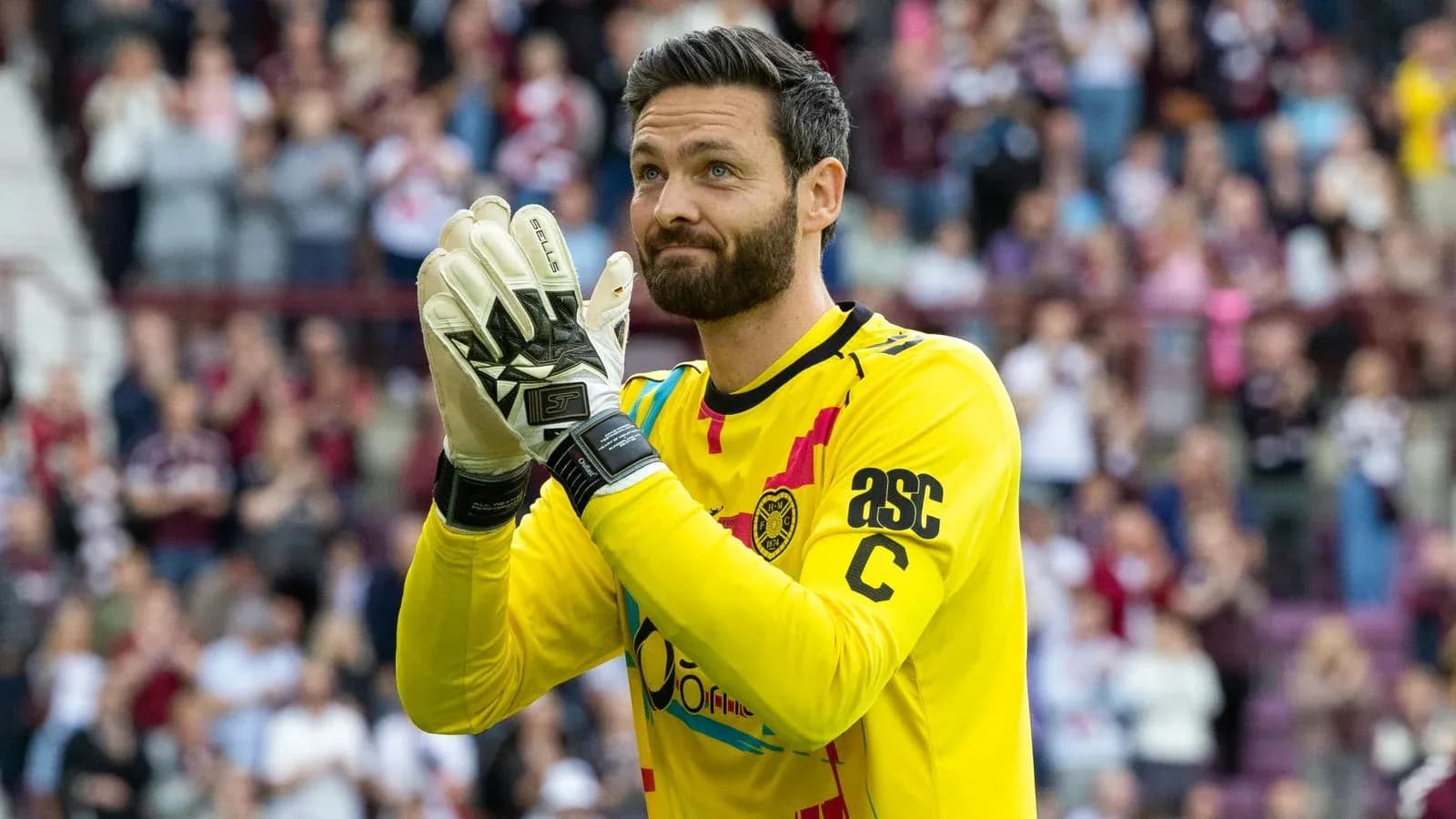 Goalkeeper applauding fans in bright yellow kit Goalkeeper applauding fans in bright yellow kit