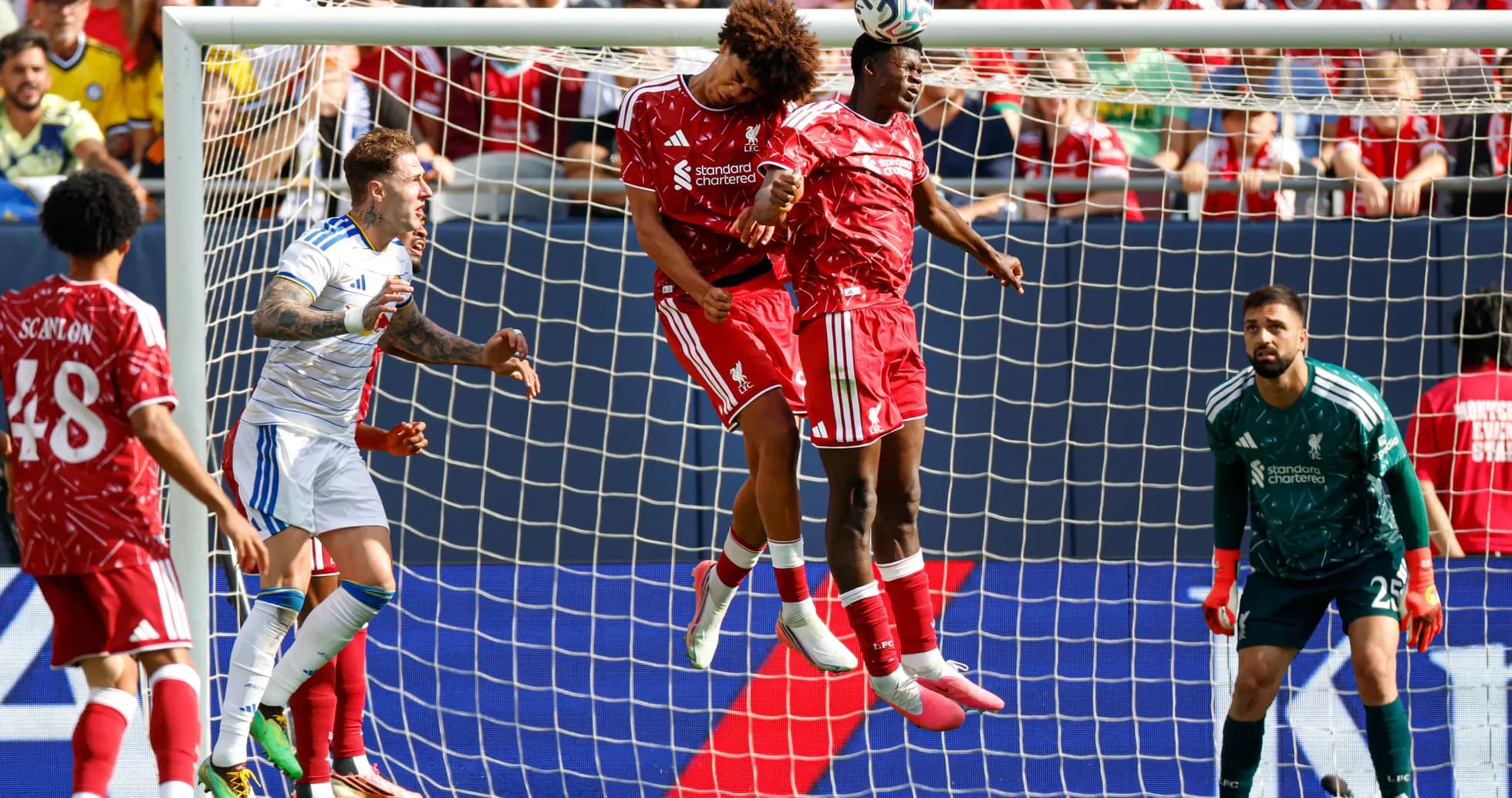 Two Liverpool players heading the ball in goal area Two Liverpool players heading the ball in goal area