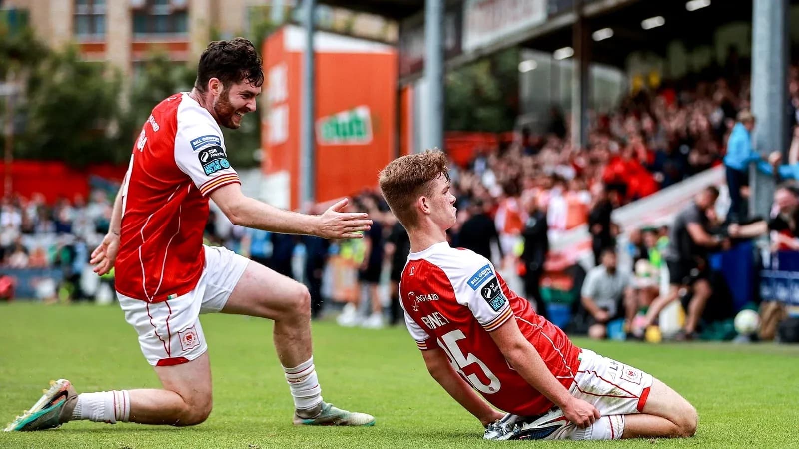 Two players celebrating a goal on the field Two players celebrating a goal on the field