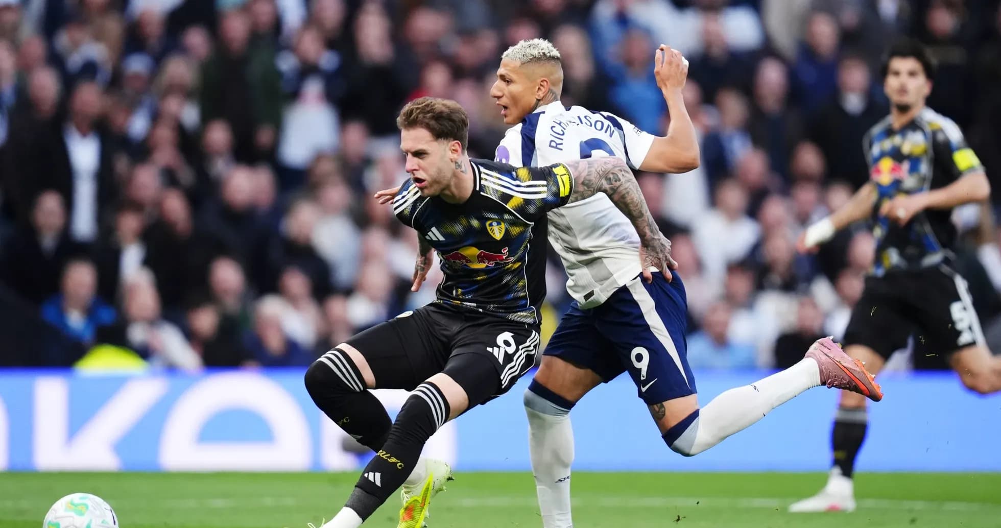 Leeds player challenged by Tottenham opponent Leeds player challenged by Tottenham opponent