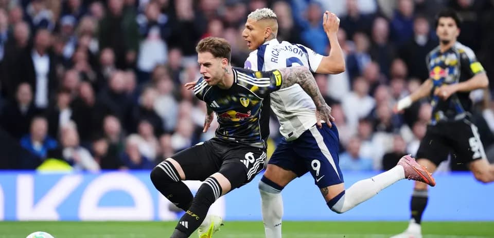 Leeds player challenged by Tottenham opponent Leeds player challenged by Tottenham opponent