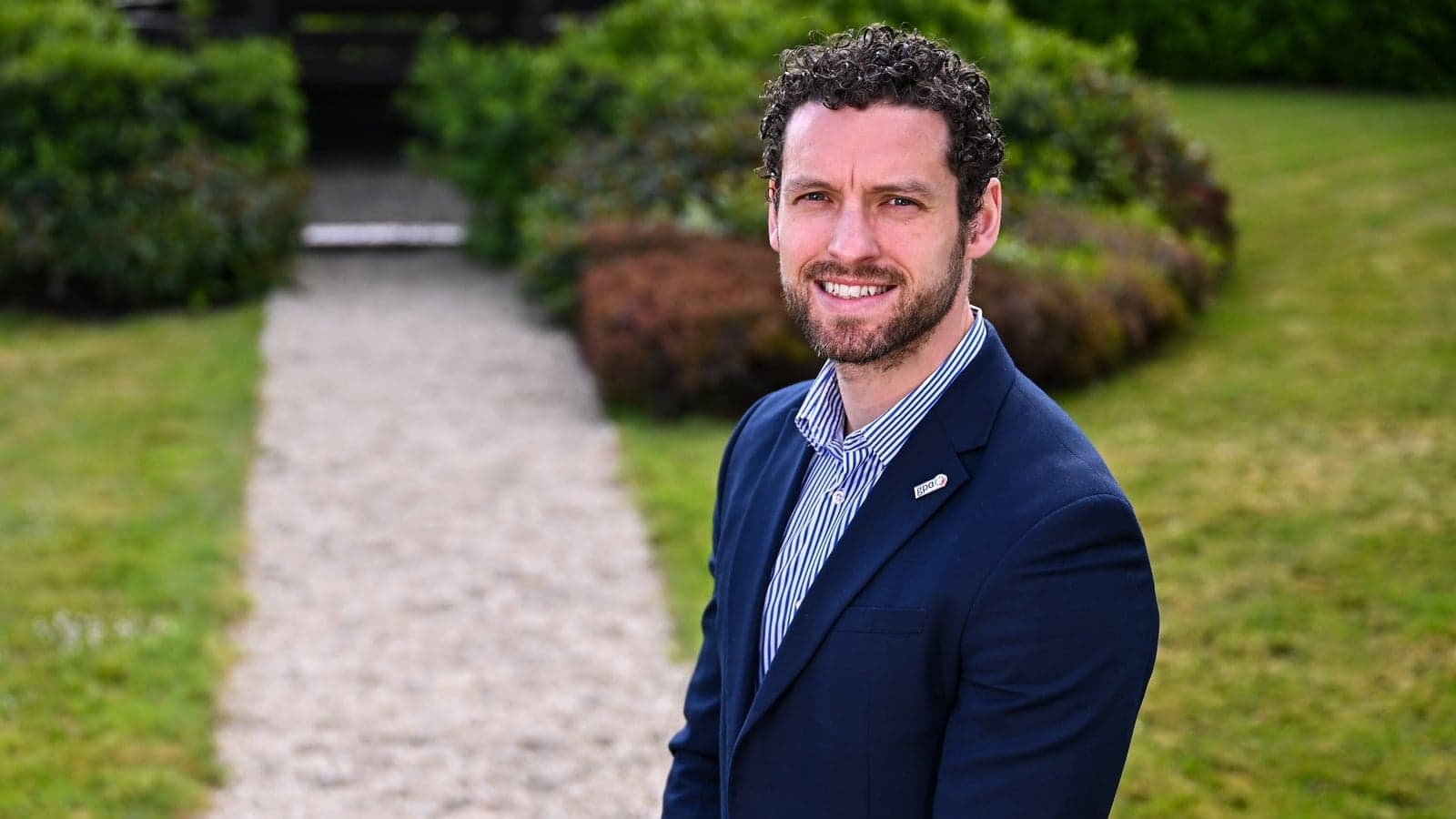 Man in a suit standing on a garden path Man in a suit standing on a garden path
