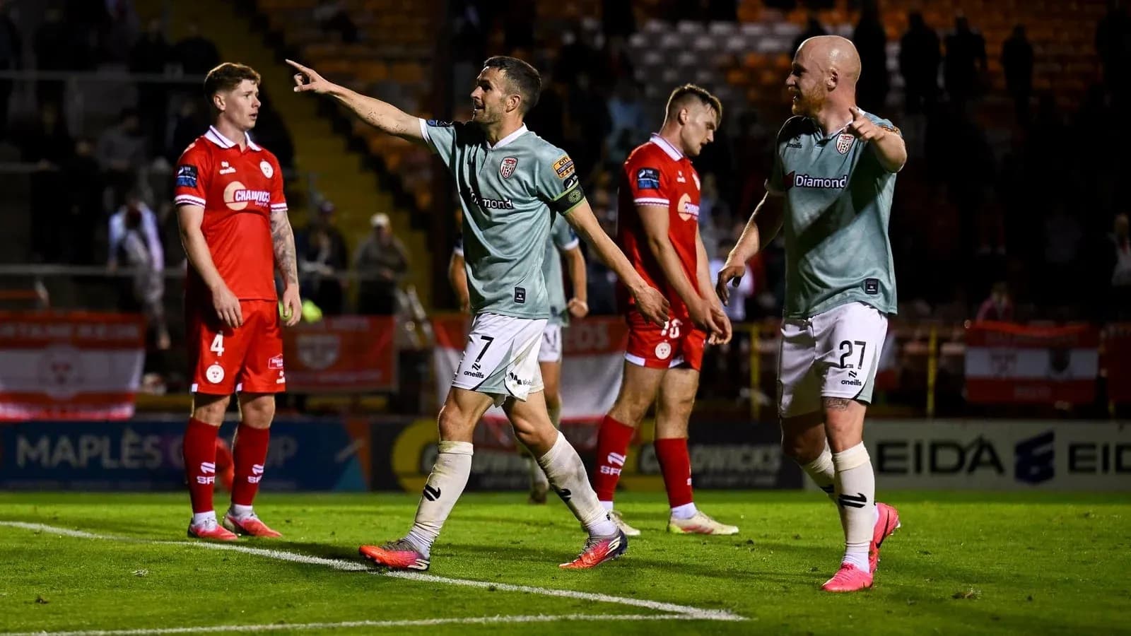 Players celebrating a goal on the pitch Players celebrating a goal on the pitch
