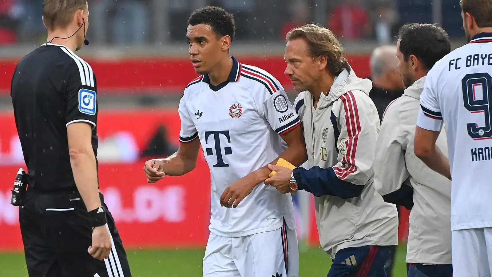 Player being substituted during a match with officials Player being substituted during a match with officials