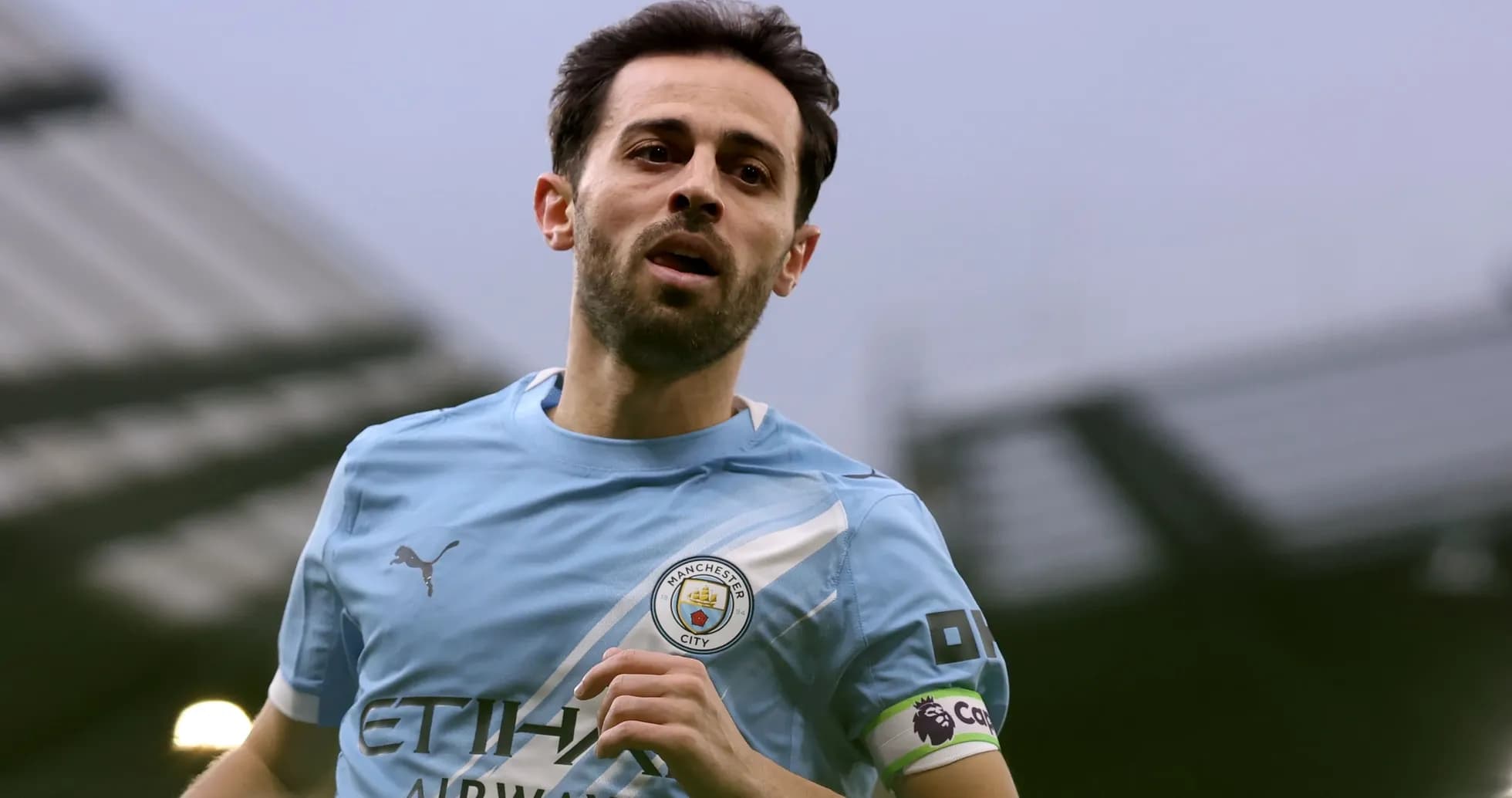 Player wearing Manchester City kit running on field Player wearing Manchester City kit running on field