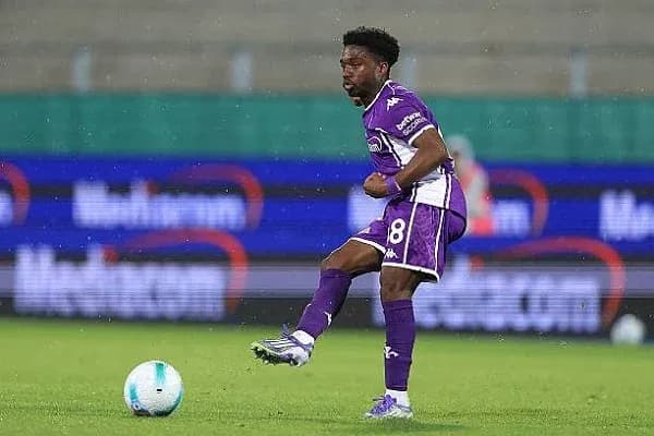 Player in purple kit kicking a soccer ball Player in purple kit kicking a soccer ball